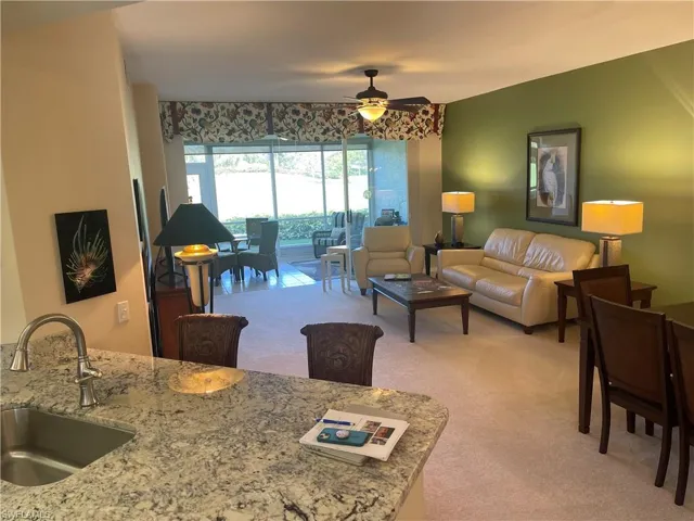 Living room featuring a ceiling fan and light colored carpet