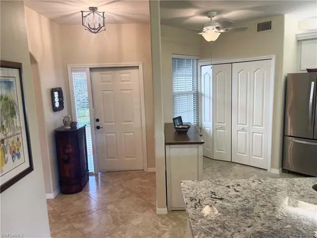 Entryway with visible vents, ceiling fan, and baseboards