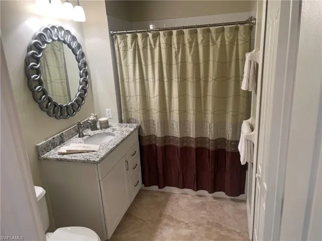 Full bathroom with vanity and a shower with shower curtain
