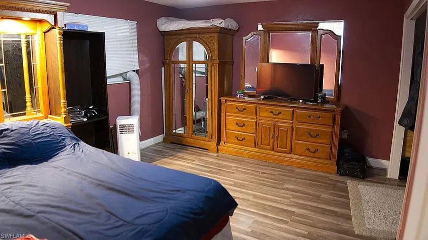 Bedroom with light wood finished floors and baseboards