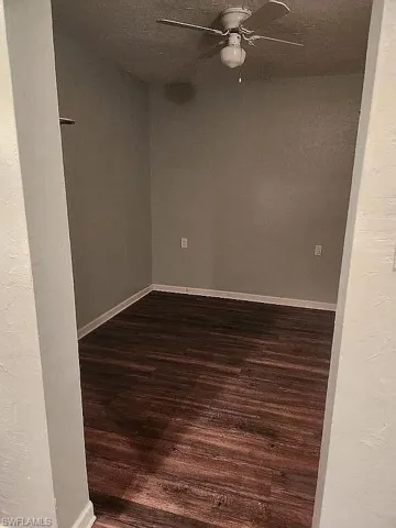 Spare room with baseboards, wood finished floors, and a ceiling fan