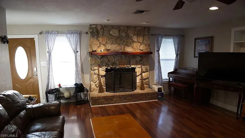 Living area featuring a wealth of natural light, visible vents, ceiling fan, and wood finished floors