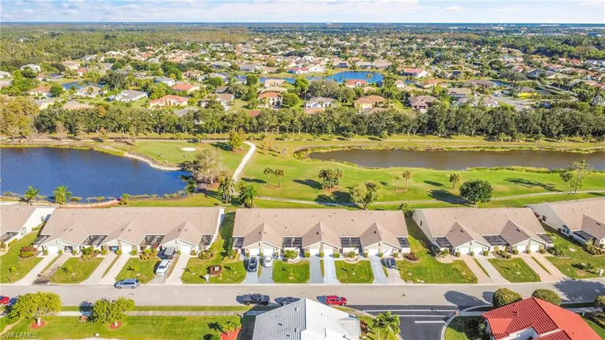 Aerial perspective of suburban area with a large body of water and a golf course