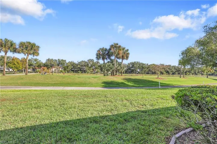 View of community with a yard and view of wooded area