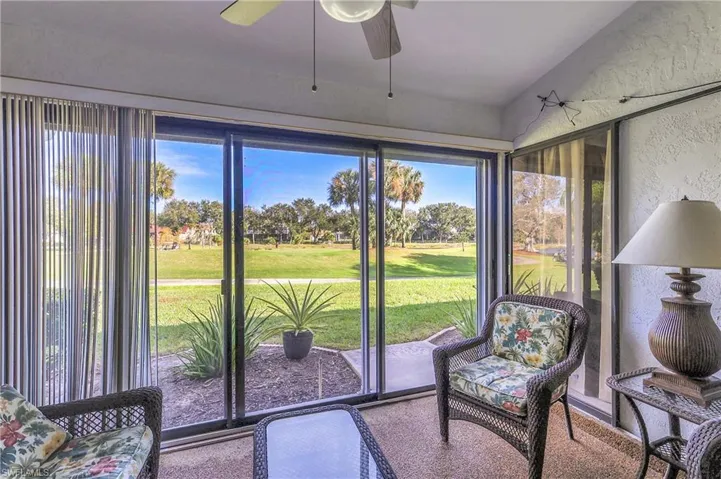 Sunroom featuring a textured wall and golf course view