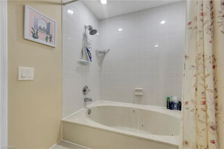 Full bath featuring a combined bath / shower with jetted tub