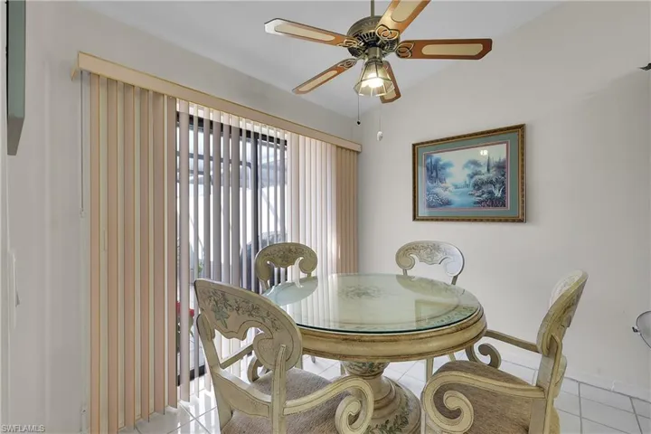 Tiled dining space featuring ceiling fan and baseboards