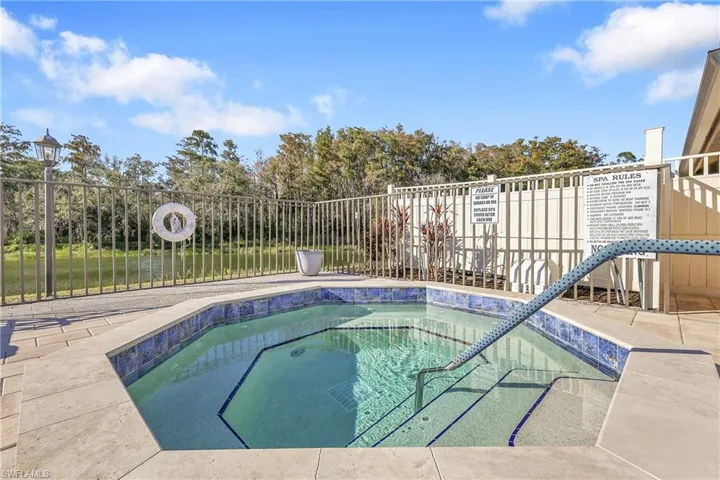 View of swimming pool with a hot tub, a patio area, and a swimming pool