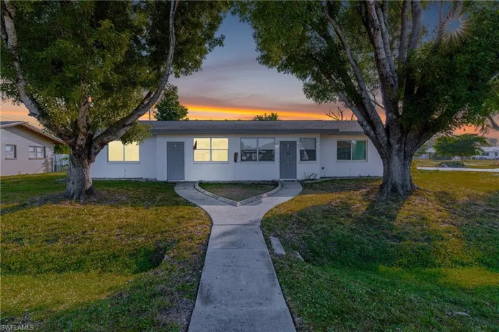 Single story home featuring a yard, stucco siding, and a shingled roof
