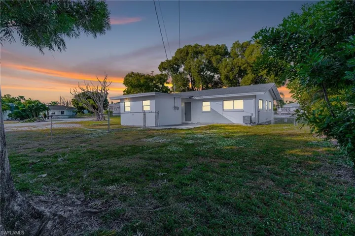Back of house at dusk featuring a patio area and stucco siding