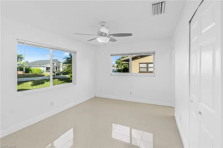 Empty room with healthy amount of natural light and a ceiling fan