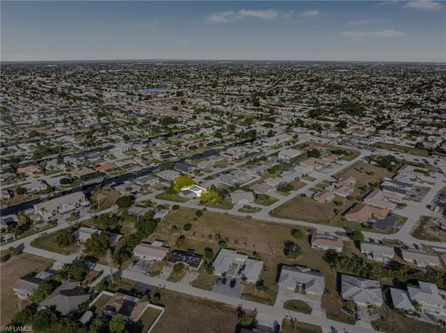 Aerial view of property and surrounding area featuring nearby suburban area