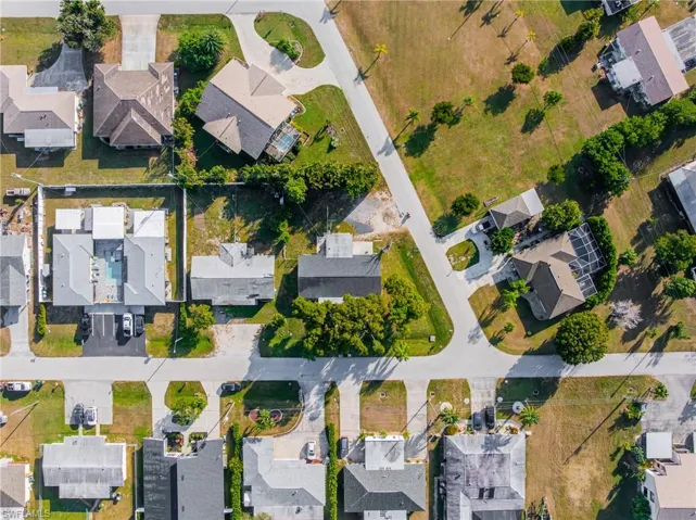Aerial view of property and surrounding area featuring nearby suburban area