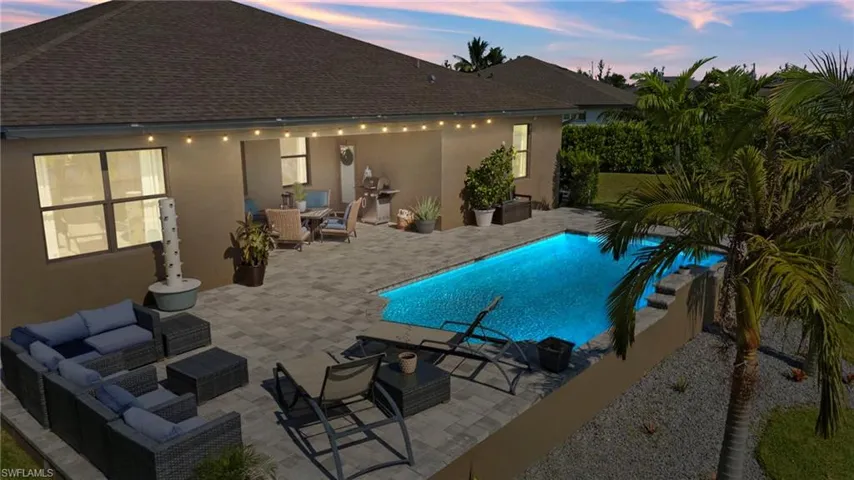 Pool at dusk featuring outdoor lounge area and a patio