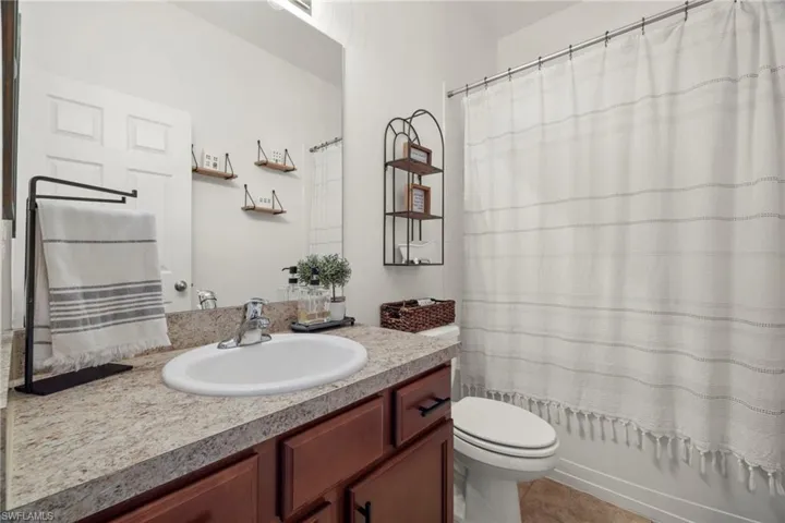 Bathroom featuring tile patterned floors, vanity, and toilet