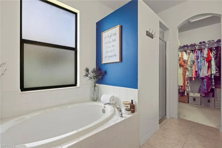 Bathroom with tile patterned floors and shower with separate bathtub