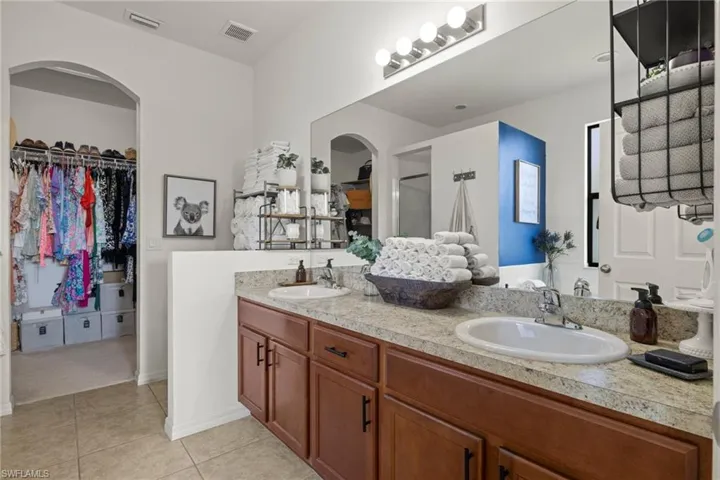 Bathroom featuring tile patterned flooring and dual vanity