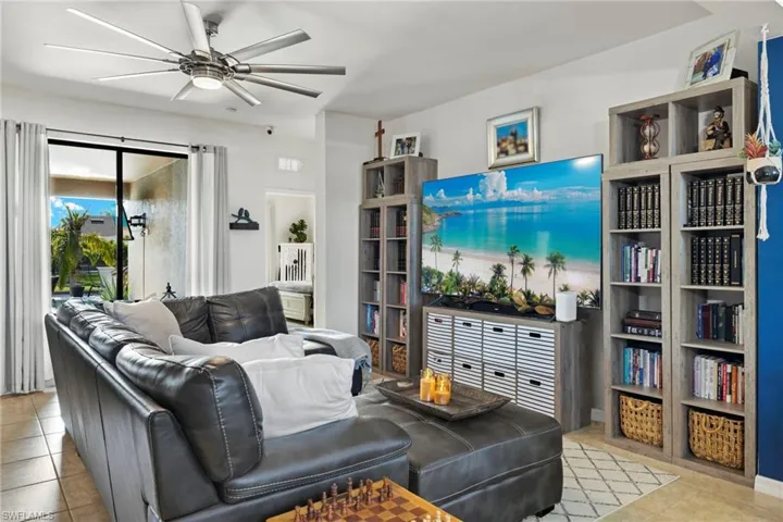 Living room with light tile patterned floors and ceiling fan