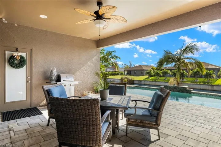 View of patio with ceiling fan and area for grilling