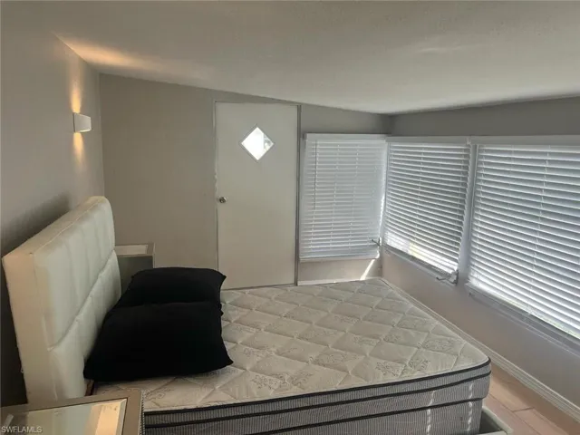 Bedroom with a textured ceiling and wood-type flooring