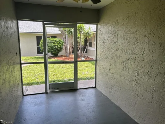 Unfurnished sunroom featuring a ceiling fan