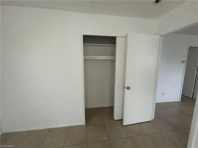 Unfurnished bedroom featuring a closet and tile patterned flooring