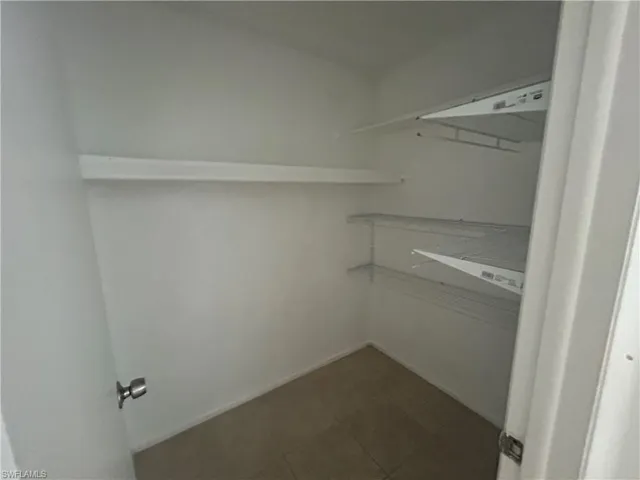 Spacious closet featuring dark tile patterned flooring
