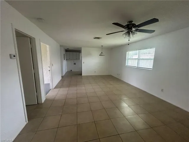 Tiled empty room featuring ceiling fan
