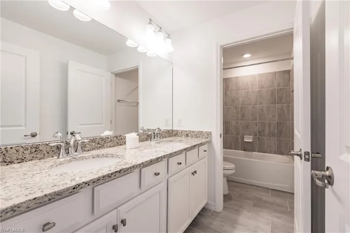 Full bathroom featuring vanity, toilet, and tiled shower / bath