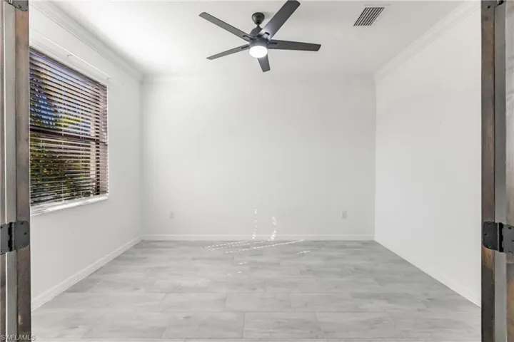 Spare room with ceiling fan and ornamental molding