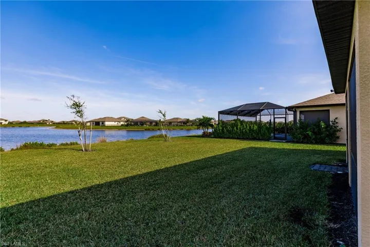 View of yard featuring a water view and glass enclosure