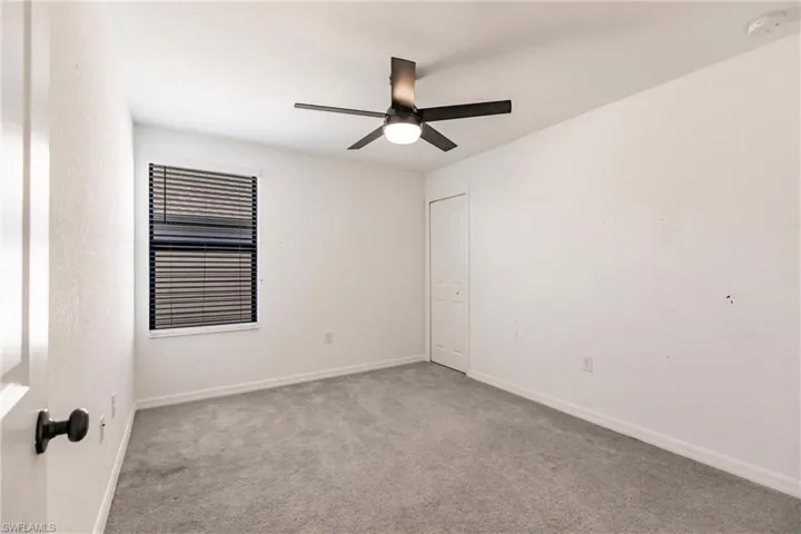 Carpeted empty room with ceiling fan