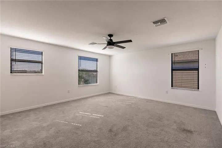 Carpeted spare room featuring ceiling fan