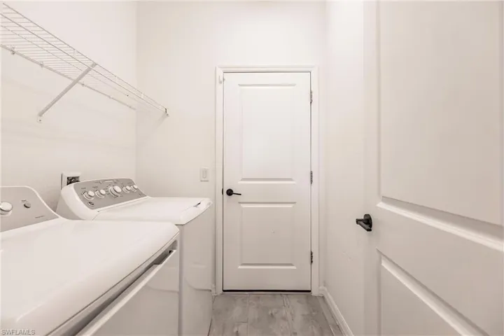 Washroom with washer and clothes dryer and light hardwood / wood-style floors
