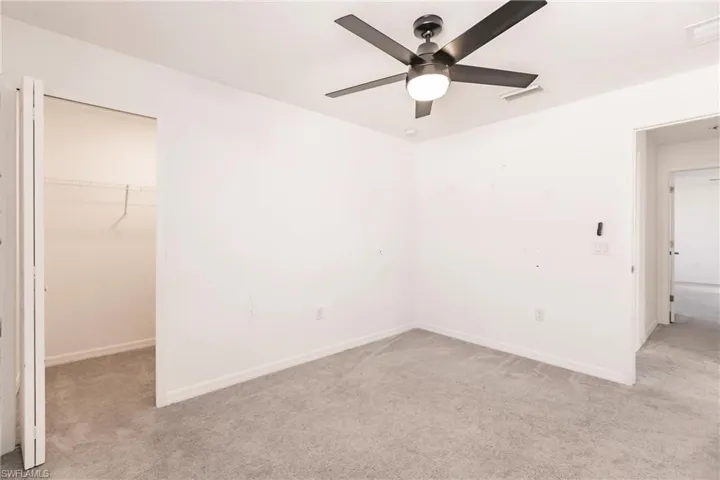 Empty room with light carpet and ceiling fan