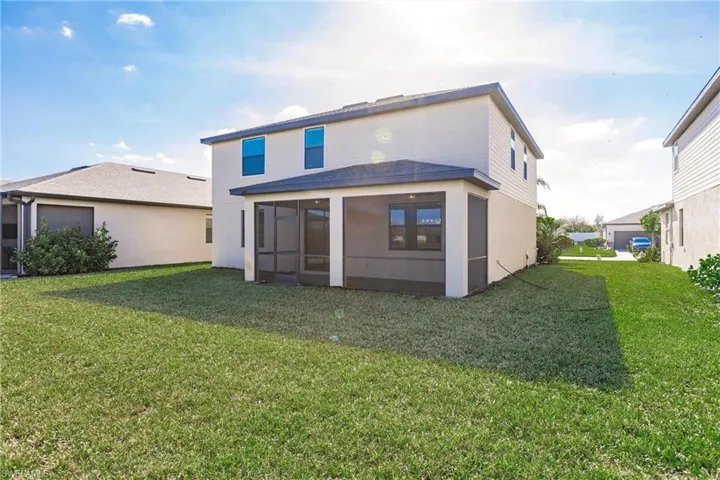 Back of property featuring a lawn and a sunroom