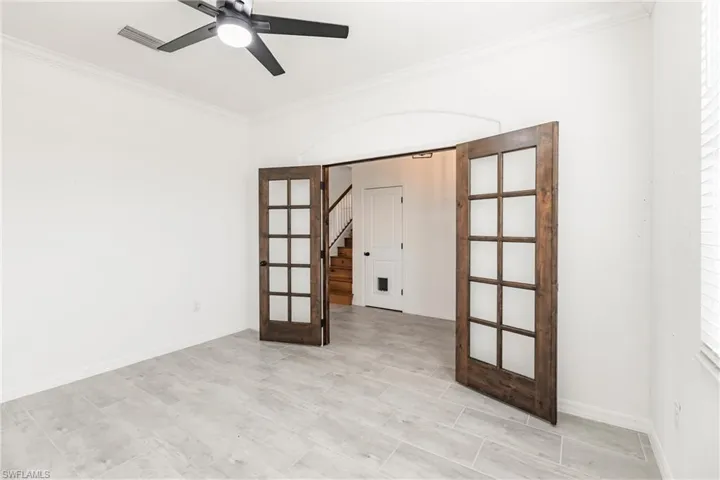 Spare room featuring french doors, ceiling fan, and ornamental molding