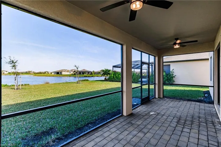 Unfurnished sunroom featuring a water view and ceiling fan