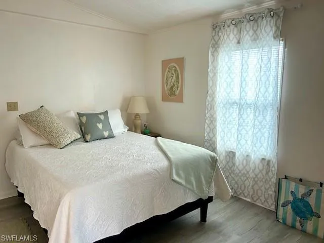 Bedroom featuring vaulted ceiling and wood finished floors