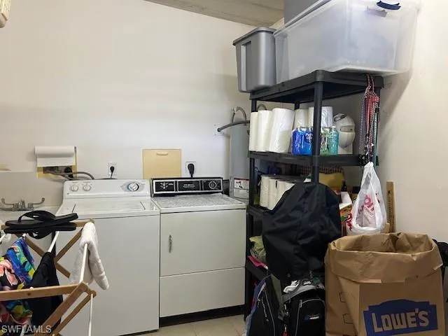 Laundry area with washer and dryer and light tile patterned floors