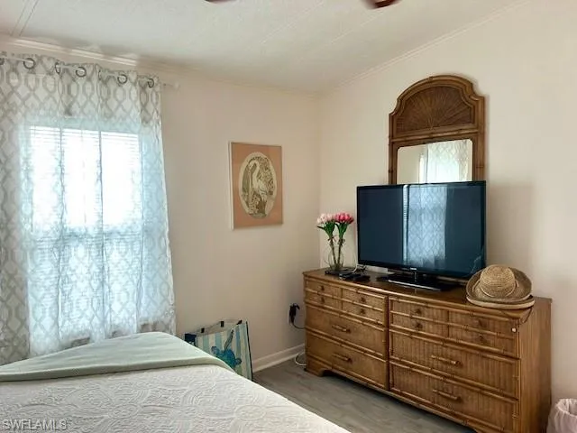 Bedroom with wood finished floors and baseboards