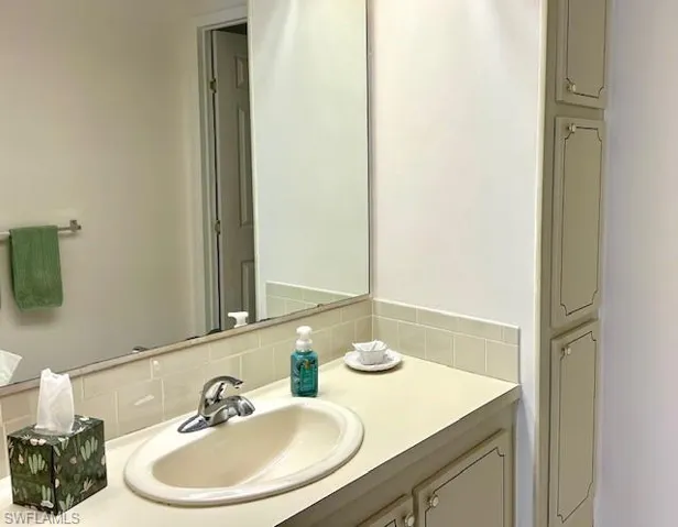 Bathroom with vanity and decorative backsplash