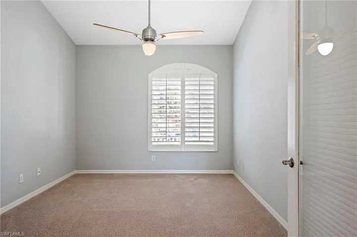 Empty room featuring carpet floors, ceiling fan, and baseboards