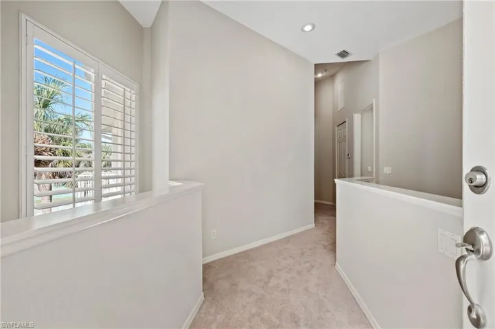 Corridor featuring visible vents, baseboards, recessed lighting, and light colored carpet