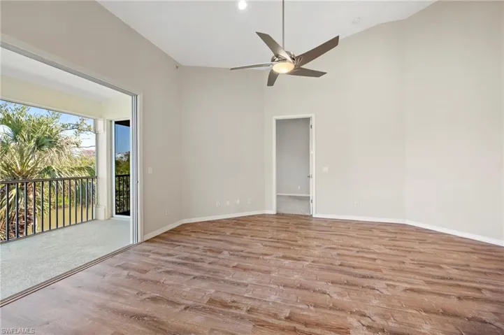 Unfurnished room with high vaulted ceiling, baseboards, a ceiling fan, and wood finished floors