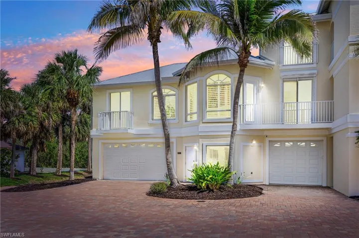 View of front of house featuring a garage, stucco siding, and decorative driveway