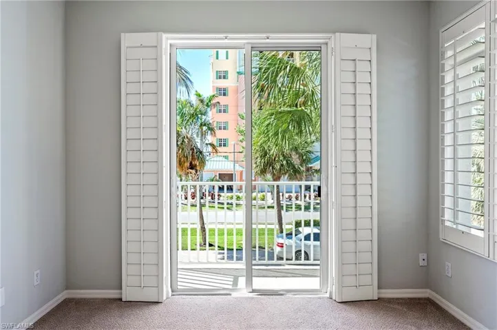 Doorway with carpet floors and baseboards