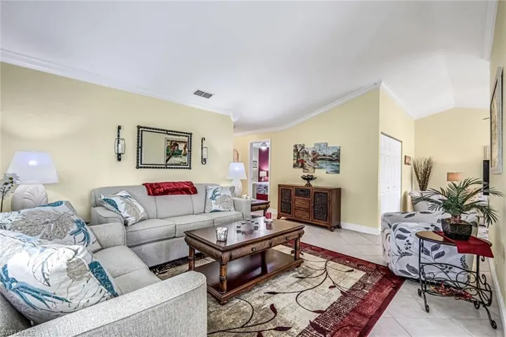 Living room featuring crown molding and vaulted ceiling.