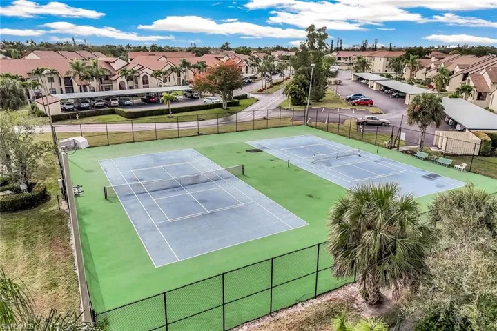 View of tennis court with a residential view.