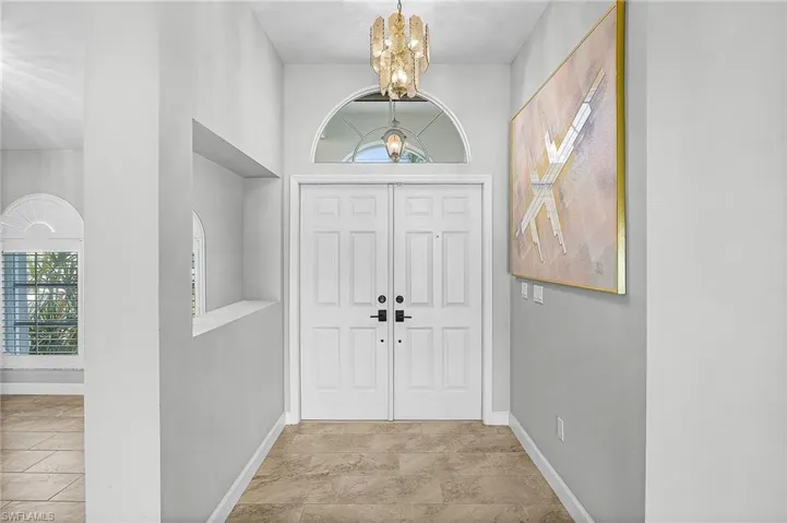 Entrance foyer with healthy amount of natural light, a chandelier, and a high ceiling